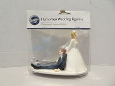 a wedding cake topper in the shape of a bride and groom sitting on a bench