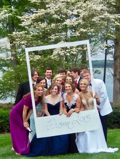 a group of people standing next to each other in front of a sign that says prom 2013