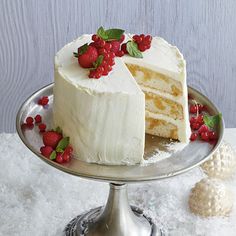 a cake with white frosting and strawberries on top is sitting on a silver platter