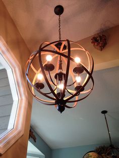 a chandelier hanging from the ceiling in a room with a round light fixture