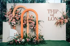 an outdoor event with flowers and greenery on the wall that says'trip or lon '