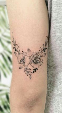 a black and white photo of a woman's arm with tattoos on it, including roses