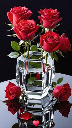 three red roses in a crystal vase on a table