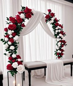 a wedding arch decorated with red and white flowers