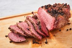 sliced meat sitting on top of a wooden cutting board