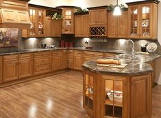 a large kitchen with wooden cabinets and granite counter tops, along with hardwood flooring