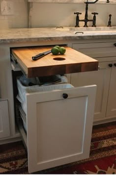 a kitchen with an island and cutting board in the middle, on top of a rug