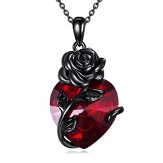 a heart shaped pendant with a rose on it's side and a red stone in the middle