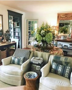 a living room filled with furniture and lots of books on top of a hard wood floor