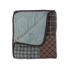 a blue and brown quilted blanket laying on top of a white wall