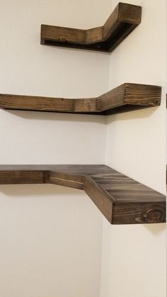 three wooden shelves on the wall in a room