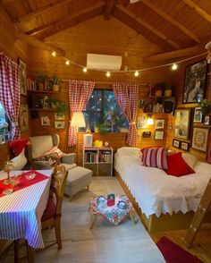 a living room filled with furniture and pictures on the wall next to a table covered in red and white checkered cloths