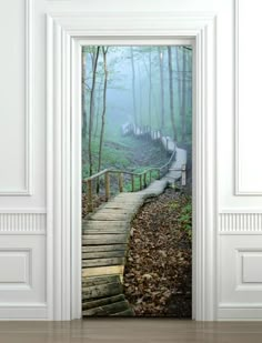 an open door with stairs in the woods on a foggy day, leading to a wooden bridge