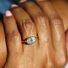 a woman's hand with a diamond ring on it