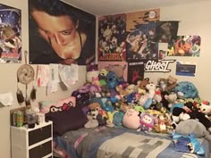 a bed with lots of stuffed animals on it in a room filled with posters and pictures