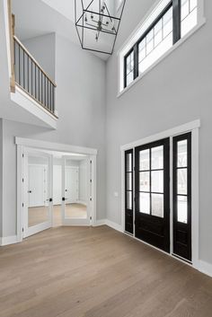 an empty room with black doors and white walls