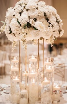 a tall centerpiece with white flowers and candles