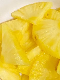 sliced up pineapple slices in a white bowl