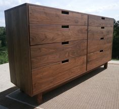 a large wooden dresser sitting on top of a cement floor next to a parking lot