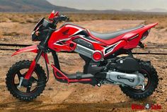 a red motorcycle parked on top of a dirt field