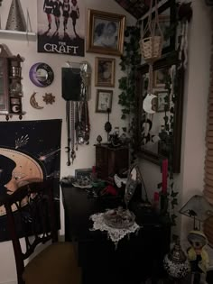 a room filled with lots of clutter and pictures hanging on the wall above it