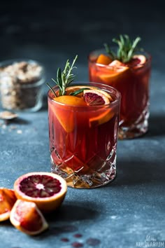 two glasses filled with blood orange punch and garnished with rosemary