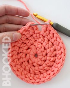 the crochet is being worked on by someone using a pair of pliers