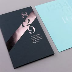 the front and back of a business card with gold foil on it, next to a blue envelope