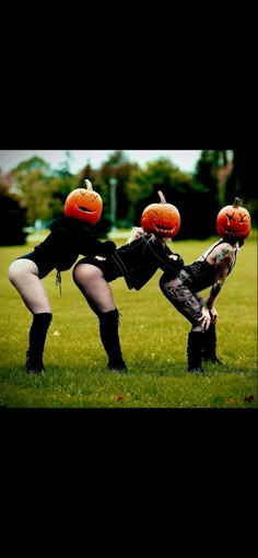 two people dressed up in halloween costumes with pumpkins on their heads and one person holding an orange ball