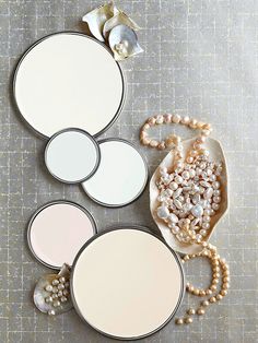 three round mirrors with pearls on the bottom and two smaller ones sitting next to each other