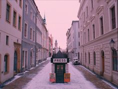 there is a sign that says press in the middle of an alley way with snow on the ground