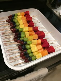 fruit skewers are lined up on a tray