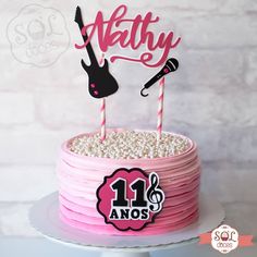 a birthday cake with pink frosting and two guitar picks