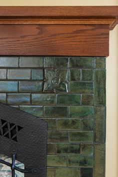 a close up of a brick fireplace with a wood mantle and metal grill grate