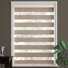 a living room with a large window covered in shades of brown and white stripes on the blinds