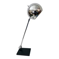 a chrome ball lamp on a black stand