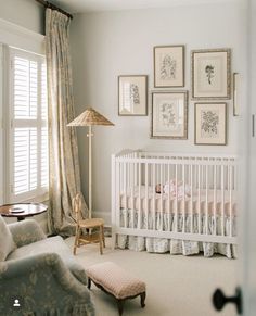 a baby's room with pictures on the wall and a crib in the corner