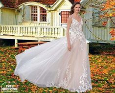 a woman standing in front of a house wearing a wedding dress with an open back