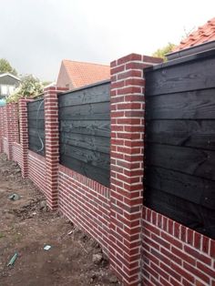 a brick fence is being built on the side of a house