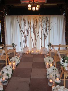 the aisle is decorated with white flowers and candles