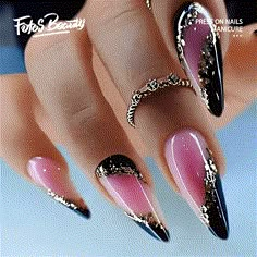 a woman's nails with pink, black and gold designs on the tip of them