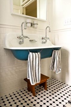 a bathroom with black and white tile flooring and a blue sink in the corner