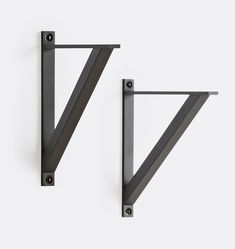 two black metal shelves with brackets on the top and bottom, one in the shape of a v