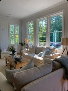 a living room filled with furniture and large windows