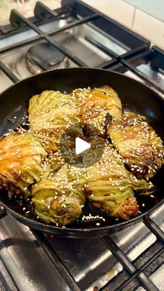 an iron skillet filled with cooked artichokes on top of a stove