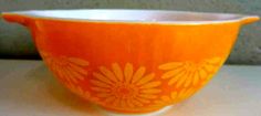 an orange and white bowl sitting on top of a table