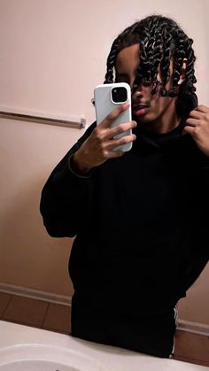 a man taking a selfie in front of a mirror with his cell phone up to his face