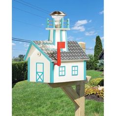 a white and blue bird house with a red door