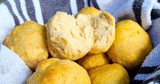 a basket filled with yellow donuts sitting on top of a blue and white towel