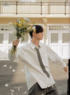 a young man holding flowers in his hands